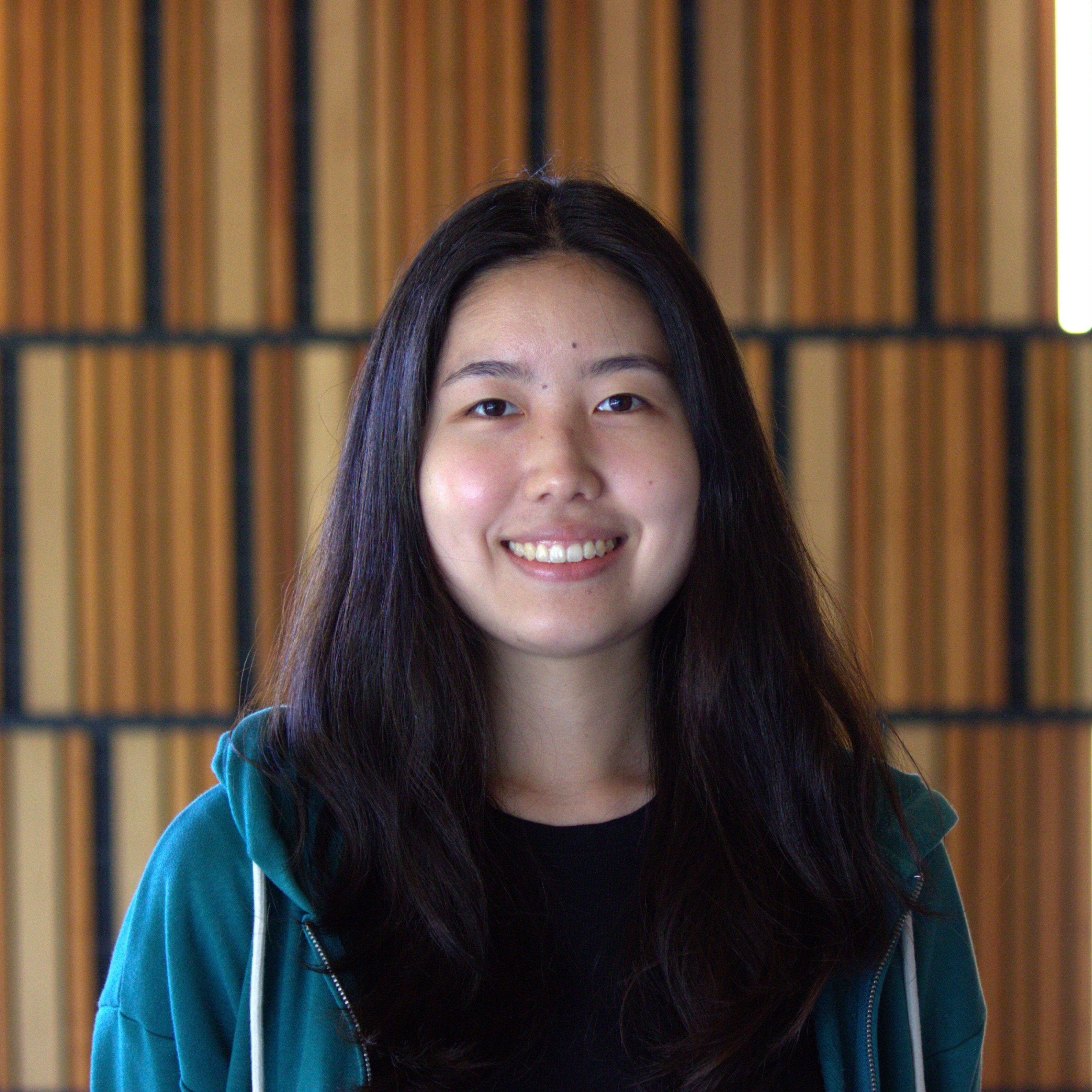 headshot of Joo, a 20-year-old Korean woman with dark hair, smiling at the camera